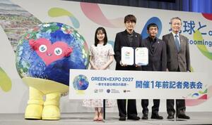 　国際園芸博覧会の開幕まで１年となり、マスコットキャラクターの「トゥンクトゥンク」と写真に納まる（左から）芦田愛菜さん、「ゆず」の北川悠仁さん、岩沢厚治さん、経団連の筒井義信会長＝１９日午前、東京都千代田区