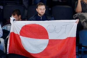 アイスホッケー男子の米国―デンマーク戦の会場で、グリーンランドの旗を掲げる観客。「ICE OUT」と書かれていた=14日、イタリア・ミラノ(共同)