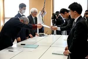 　担当者と面談し、控訴せず早急に患者認定するよう求める要請書を手渡す原告弁護団の弁護士ら（左）＝１７日午後、新潟県庁