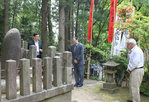 新羅王碑を参拝する呉栄煥・在新潟韓国総領事。右は海津和恵さん=燕市中島
