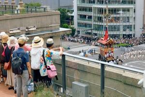 2024年7月、京都市役所の屋上から祇園祭の山鉾巡行を見る参加者ら(同市提供)