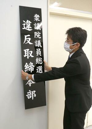 選挙違反取締本部の看板を掲げる青木竜輔知能犯捜査官=10月10日、県警本部