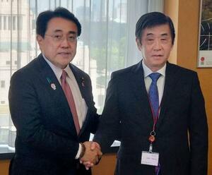 赤沢経済再生相(左)と握手する日本自動車工業会の片山正則会長=17日午前、東京都千代田区