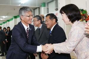 当選確実となり、市議らに握手をして回る桜井雅浩さん=11月17日午後9時前、柏崎市田中