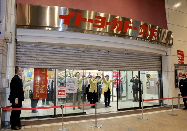 閉店でシャッターが下りる中、イトーヨーカドー丸大新潟店の店員たちは集まった市民に感謝を込めて手を振った＝１月２６日午後７時過ぎ、新潟市中央区