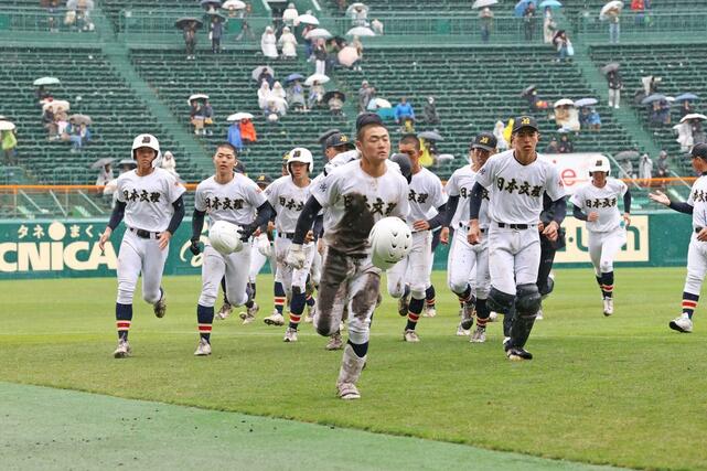 スタンドへのあいさつを終え、引き上げる日本文理の選手たち＝２５日、甲子園球場