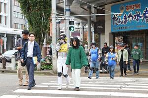 横断歩道を渡る「盲ろう者」、「妊婦」、「車いす」の体験者ら=長岡市大手通1