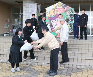 三条中央ライオンズクラブに、プルタブリングを手渡す大島中学校の生徒代表(左)=三条市大島