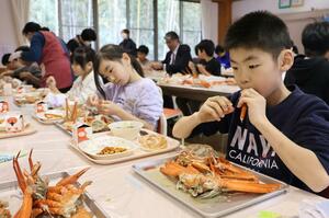 給食でベニズワイガニを味わう児童＝佐渡市赤泊