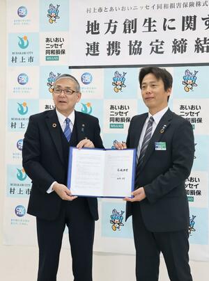 協定を結んだ村上市の高橋邦芳市長(左)とあいおいニッセイ同和損害保険新潟支店の松﨑浩平支店長=27日、村上市役所