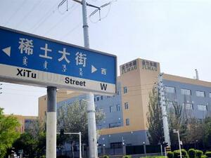 「レアアース大通り」と書かれた道路標識。奥はレアアース磁石大手「江西金力永磁科技」=7月、中国内モンゴル自治区包頭市(共同)
