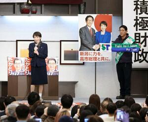 応援演説に訪れた首相の高市早苗(左)と、高市グッズのタオルを掲げてアピールする高鳥修一=2日、上越市