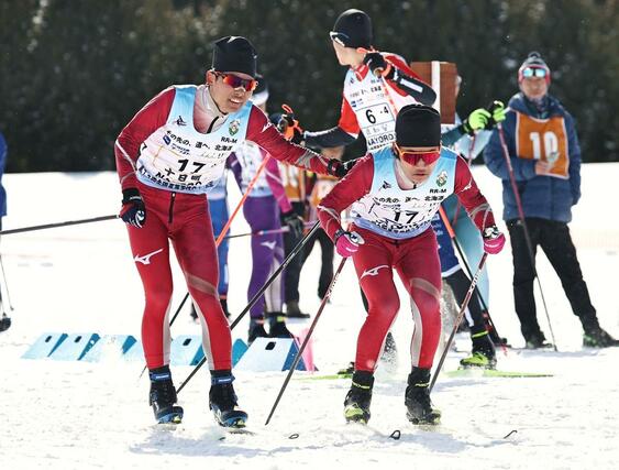 男子40キロリレー 十日町の3走根津和弘(左)からアンカー坂詰真吾にリレー=2月11日、北海道名寄市