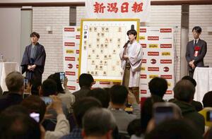 大盤解説会で将棋ファンを前に対局を振り返る藤井聡太棋王(中央)と伊藤匠七段(左)=3月3日、新潟市中央区の新潟グランドホテル