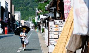 猛暑日となった岐阜県美濃市で日傘を差す児童=7日午後