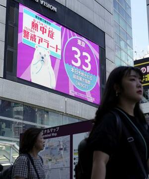 街頭モニターに表示された「熱中症警戒アラート」と暑さ指数=7月、東京・新宿