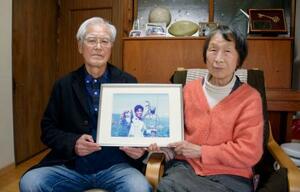 　服部剛丈さんの写真を持つ母美恵子さん（右）と父政一さん＝１３日、名古屋市