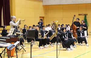 母校の第二中学校で即興演奏を楽しむTOKUさん(左)と吹奏楽部員ら=三条市興野1