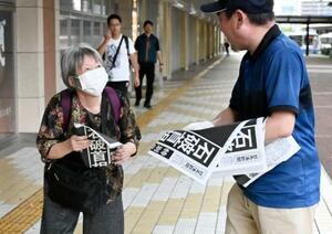 石破首相が辞任の意向を固めたことを伝える号外を受け取る女性=7日午後5時19分、JR鳥取駅前