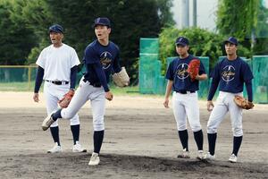 投球練習に励む新潟産大付の投手陣。吉野公浩監督(左)がアドバイスを送る