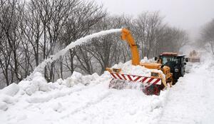 勢いよく雪を巻き上げながら進むロータリー除雪車=4月4日、佐渡市の大佐渡スカイライン
