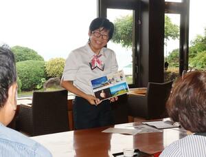 フロントスタッフとして笑顔で応対するティンティンチィーさん=佐渡市相川大浦