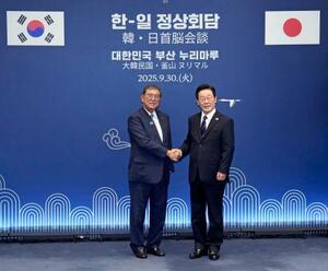 会談前に、韓国の李在明大統領(右)と握手する石破首相=30日、釜山(共同)