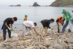 漂着ごみを拾い集める地域住民ら＝柏崎市青海川