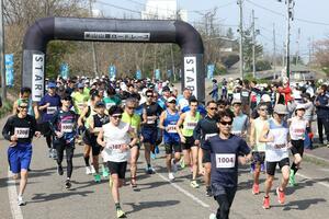 声援を受けてスタートを切る「米山山麓ロードレース」のランナーたち＝１９日、上越市柿崎区
