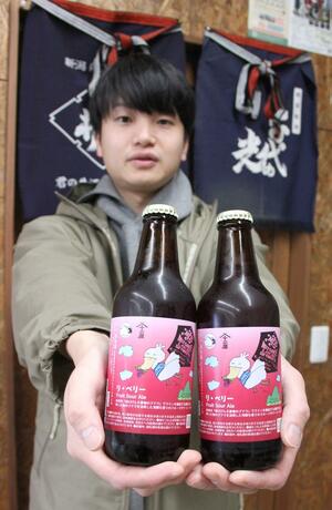 ブドウの搾りかすを副原料にしたビール「リ・ベリー」を手にする川上晃平店長＝妙高市関山の十二屋