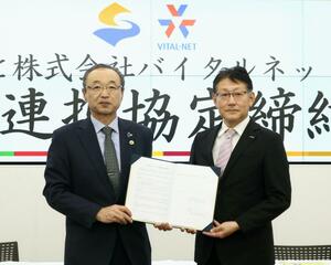 連携協定を結んだバイタルネット新潟第一支店の曽我武久支店長（右）と渡辺竜五市長＝佐渡市千種