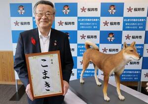 愛称が決まった復元模型の「こまき」と記念写真に納まる奈良県桜井市の松井正剛市長=6日午後、桜井市役所