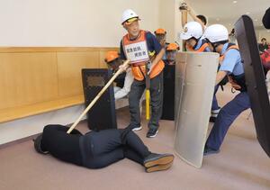 クマを建物内に追い込み、猟銃で捕獲する訓練の参加者=25日、新発田市中央町5