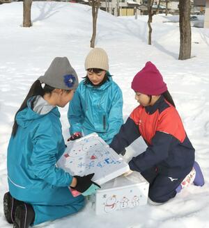 沖縄県の小学校に贈る雪を箱に詰める六日町小の5年生=1月27日、南魚沼市六日町
