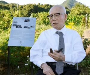 米軍機撃墜地点付近に設置された銘板の前で取材に応じる森重昭さん=28日午後、山口県柳井市