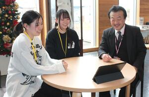 ユーチューブで校歌を聴く（左から）真島玲奈さん、山口心奈さん、白倉政典学校長＝三条市上須頃