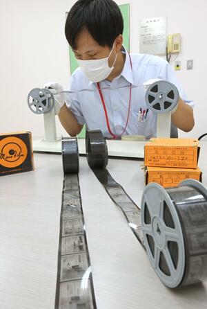 収蔵されているマイクロフィルムの状態を確認する図書館司書=新潟市中央区女池南3の県立図書館