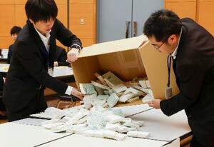 　茨城県神栖市長選を巡り、再点検する票を箱から取り出す職員＝２１日午前、水戸市