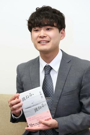 エネルギーフォーラム小説賞を受けて書籍化された「跳ねる、跳ねる。」を持つ佐藤凜さん=新潟日報長岡支社