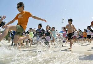 5月、和歌山県白浜町の白良浜が海開きし、一斉に海へ駆け込む海水浴客