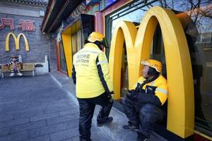 北京市内のファストフード店で待機する配達員=2025年12月(共同)