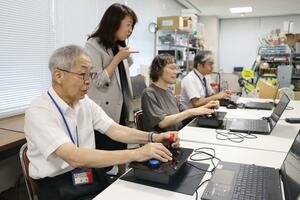 大阪・関西万博のeスポーツ大会に向けて練習する加茂市老人クラブ連合会のメンバー=加茂市幸町2