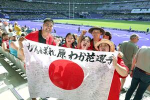 地元から贈られた寄せ書き入りの日の丸を手にする原わか花選手の家族=7月28日、パリ郊外サンドニのフランス競技場