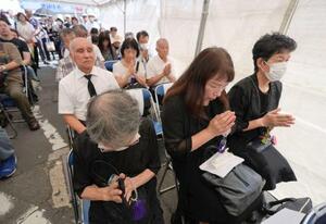 「京橋駅空襲」から80年となり、JR京橋駅前で営まれた慰霊祭で、犠牲者を追悼する参列者たち=14日午前、大阪市