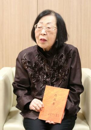 自費出版した作品集を手に語る古俣キヨさん＝新潟市中央区万代３