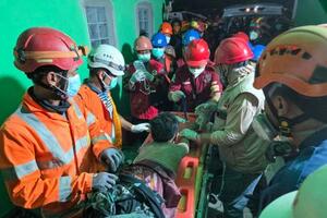 1日、インドネシア・シドアルジョで、倒壊したイスラム寄宿学校の建物で救助活動をする救急隊員(国家捜索救助庁提供・ゲッティ=共同)