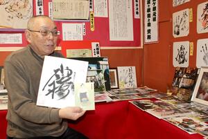 安照寺本堂の展示コーナーで、琴桜関の手形を持ち初優勝の喜びを語る梶井照雄さん=佐渡市春日