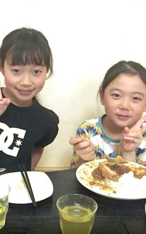 一緒にご飯を食べる当時１０歳の上村海音さん（左）と８歳の工藤璃星選手＝村上市