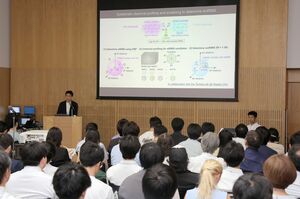 脳内の画像化のために使う薬液の開発について講演する三國貴康教授=24日、新潟市中央区