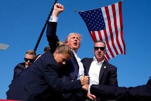 昨年7月、選挙集会で銃撃を受け、大統領警護隊に囲まれながら拳を上げるトランプ氏=米ペンシルベニア州バトラー(AP=共同)